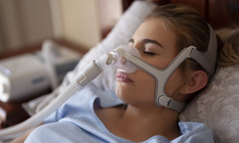 young woman in bed cpap machine